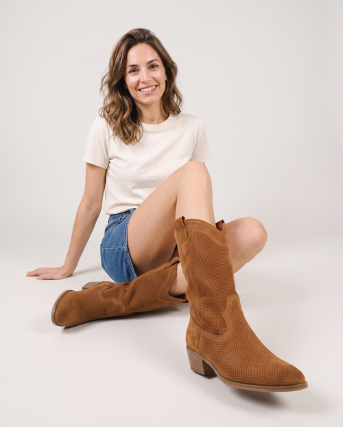 Bottes santiag en daim perforé brun portées, pose assise au sol